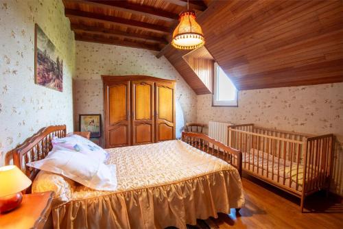 a bedroom with two beds and a chandelier at Meuble de tourisme au recoux in Le Recoux
