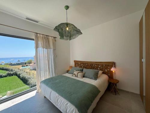 une chambre avec un lit et une grande fenêtre dans l'établissement Charmante maison face à la mer, à Sainte-Maxime