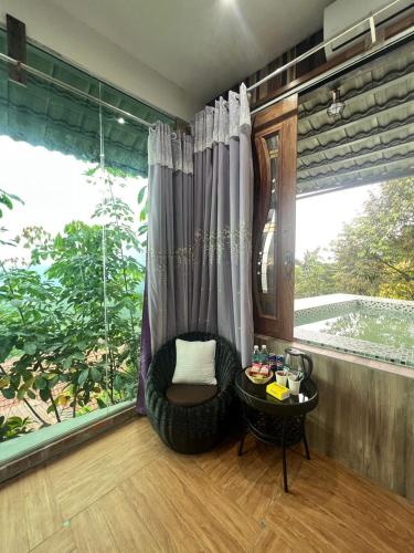a room with a chair and a large window at SANKARA GARDEN in Pantai