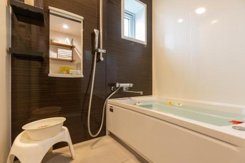 a bathroom with a tub and a toilet and a sink at Comfort Villa OKINAWA in Yabu