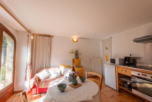 un salon avec une table et une cuisine dans l'établissement Gite pratlong, à Saint-Pierre-des-Tripiers