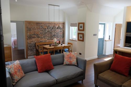 a living room with a couch and a table at The Coach House at Hoods Croft in Lewes