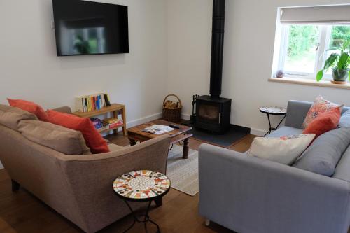 a living room with two couches and a fire place at The Coach House at Hoods Croft in Lewes