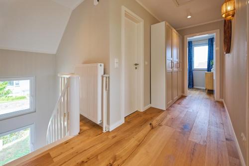an empty hallway with wooden floors and a staircase at Lykke Hus - Wohnung Fridas Ausblick OG in Timmendorfer Strand