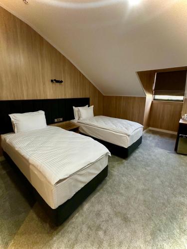 two beds in a hotel room with two bedsvisor at WELLFORT HOTEL in Samarkand