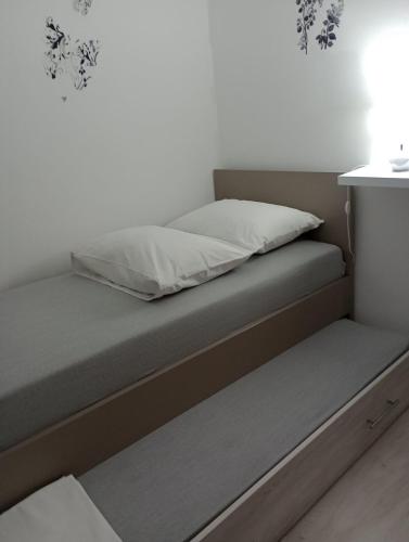 a bed in a white room with at Apartment Olive in Jovići