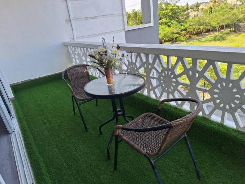 a table and two chairs on a balcony with grass at Elkhart Suites-siloam Shanzu in Shanzu
