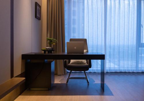 a desk with a laptop on it in a room at Maison New Century Hotel Cixi Hangzhou Bay in Cixi