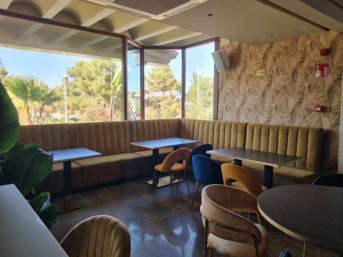 a restaurant with tables and chairs and a bench at Hotel Boutique Mirasierra in Villacañas