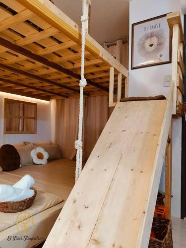 a loft bed with a wooden table in a room at El Nissi Staycation, The Play Cabin, Beside Enchanted Kingdom in Santa Rosa