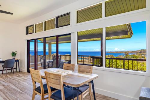 a dining room with a table and chairs and large windows at Kapalua Ridge 1421 in Kahana