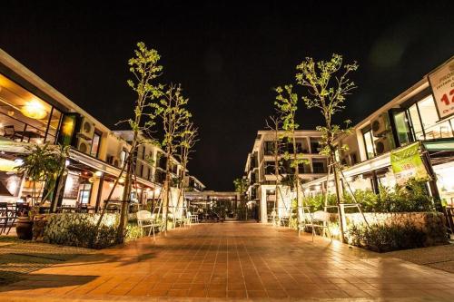 an empty street at night with trees and buildings at The Title Beach Front in Rawai Beach