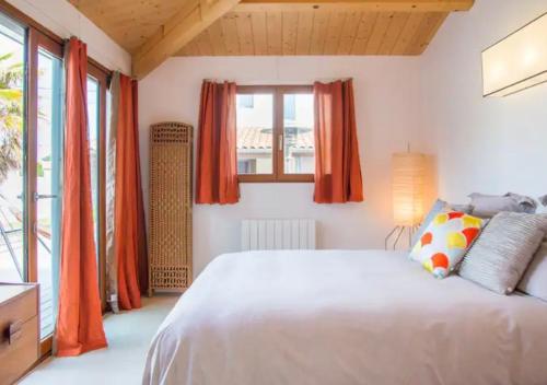 - une chambre avec un grand lit et des rideaux orange dans l'établissement Chambre indépendante avec salle de bain, à Les Sables-dʼOlonne