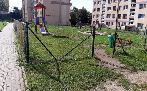 an empty park with a playground with a fence at Apartament Laurka in Kamienna Góra
