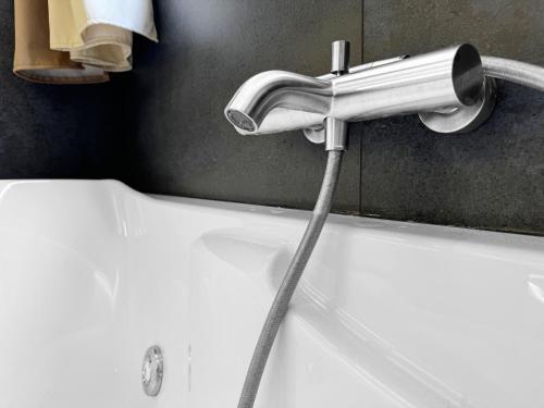 a bath tub with a hose coming out of a faucet at Marina Home - luxury apartament nel cuore di Catania in Catania
