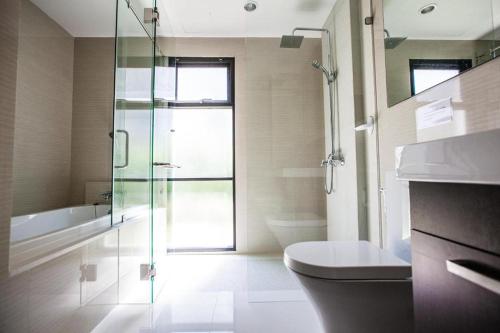 a bathroom with a glass shower and a toilet at The Title Beach Front in Rawai Beach