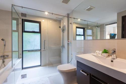 a bathroom with a shower and a toilet and a sink at The Title Beach Front in Rawai Beach