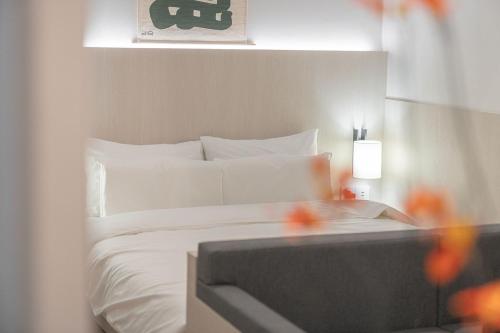 a bedroom with a bed with white sheets and a tv at Simdo Hotel&Spa Sillim by Aank in Seoul