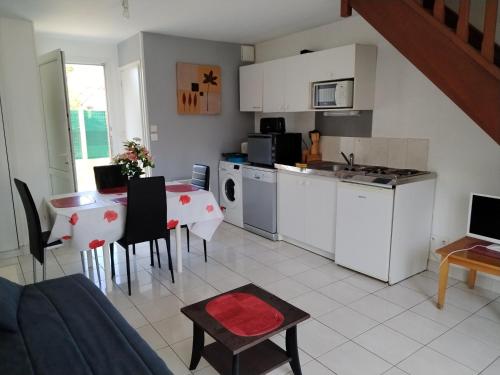 une cuisine et une salle à manger avec une table et une cuisine ainsi qu'une chambre dans l'établissement clos st paul, à Fort-Mahon-Plage