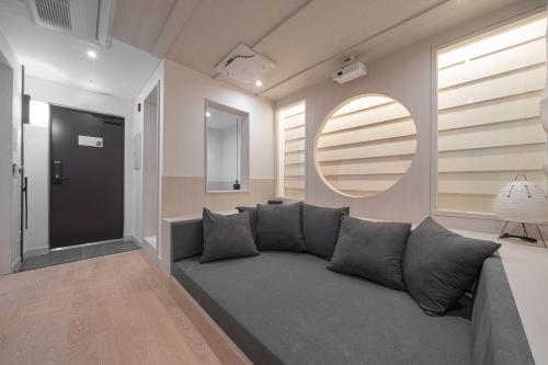 a living room with a gray couch and a mirror at Simdo Hotel&Spa Sillim by Aank in Seoul