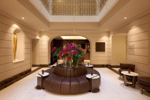 a lobby with a large vase of flowers on a table at The First Arte - Preferred Hotels & Resorts in Rome