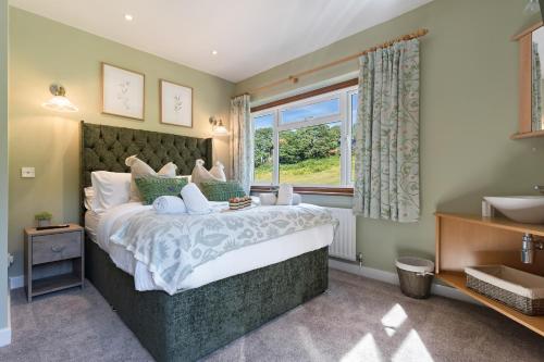 a bedroom with a large bed and a window at Stunning Countryside Home in Surrey by 53 Degrees Property, Ideal for Family Getaways, Private Tennis Court! in Hascombe