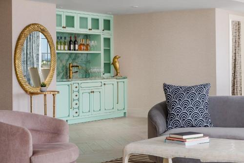 a living room with a blue cabinet and a chair at The Goodtime Hotel, Miami Beach a Tribute Portfolio Hotel in Miami Beach