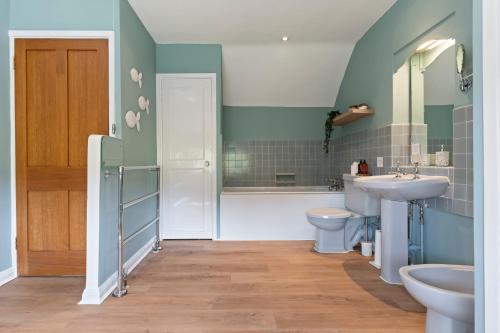 a bathroom with a sink and a toilet at Stunning Countryside Home in Surrey by 53 Degrees Property, Ideal for Family Getaways, Private Tennis Court! in Hascombe