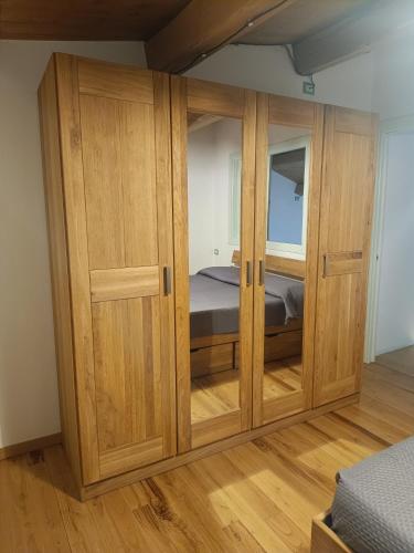 a wooden cabinet in a bedroom with a bed at La Dimora degli Scalzi Cabras in Càbras