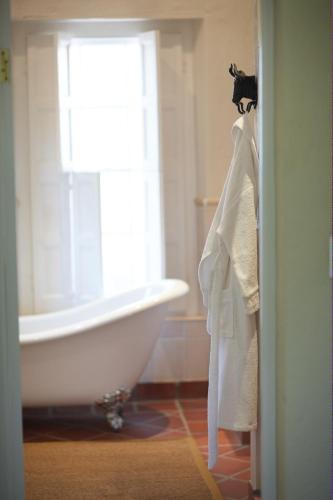 a bathroom with a white tub and a window at Explorers Club in Franschhoek