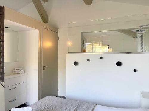 une chambre avec un lit blanc et un miroir dans l'établissement Villa d'Arnaud, à La Garde-Freinet