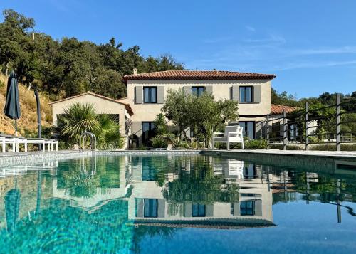 une grande piscine devant une maison dans l'établissement Villa d'Arnaud, à La Garde-Freinet