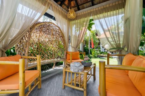 an outdoor room with orange chairs and a swing at The Kembali Luxury Villa - Melaka 5 Bedroom in Melaka