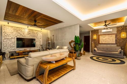 a living room with a tv and a couch and a table at The Kembali Luxury Villa - Melaka 5 Bedroom in Melaka