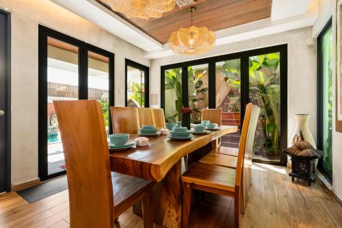 a dining room with a wooden table and chairs at The Kembali Luxury Villa - Melaka 5 Bedroom in Melaka