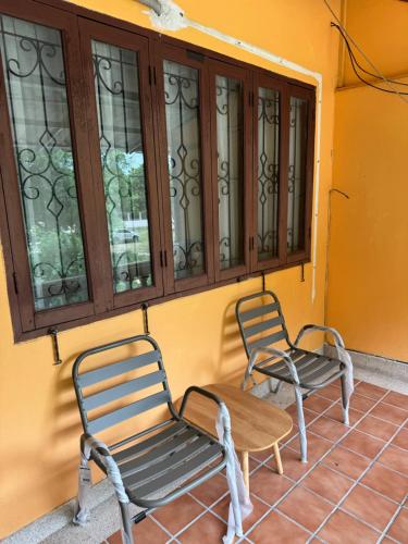 two chairs and a table in front of a window at Dikachaya Hostel in Chaweng
