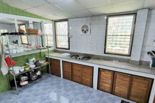 cocina con paredes de azulejos verdes y blancos en 4 Bedroom with Air-con, Quiet, Near shop, en Ban Chong U