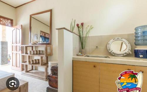 a bathroom with a sink and a counter with a mirror at The Bali Boarding House in Uluwatu