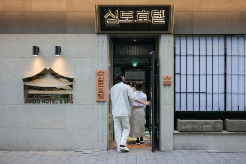 a man and woman standing outside of a building at Simdo Hotel&Spa Sillim by Aank in Seoul