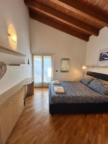 a large bedroom with a bed and a kitchen at Mansarda del Gallo Attico Vista Lago con Piscina in Salò