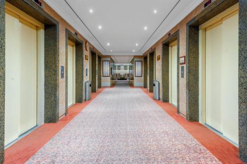 an empty hallway in a building with a carpet at Palestine Hotel Makkah in Makkah