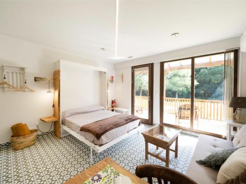 a bedroom with a bed and a living room at Cabaña del Molinero in Palas de Rei