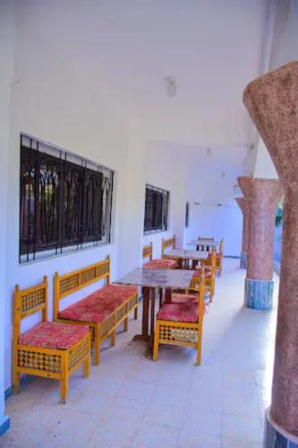 a room with wooden benches and tables and windows at Rose Guest House in Luxor