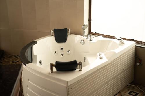 a bath tub with a mirror and a sink at Narwar Lakefront Resort in Shivpurī