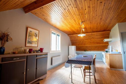 une cuisine avec une table et une salle à manger dans l'établissement Gîte Appartement 4/6 personnes, à Aumont-Aubrac