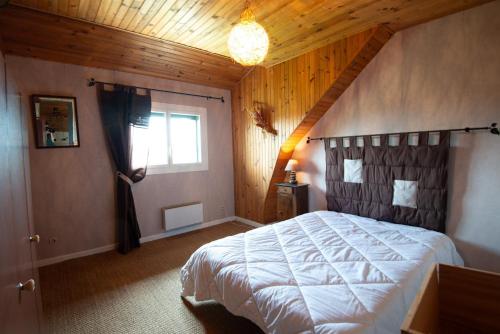 une chambre avec un grand lit dans un grenier dans l'établissement Gîte Appartement 4/6 personnes, à Aumont-Aubrac
