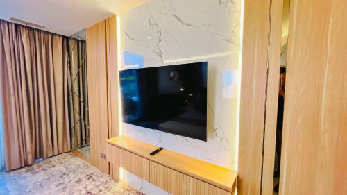 a flat screen tv on a wall in a room at Grandia Hotel in Bandung
