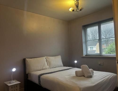 a bedroom with a bed with two towels on it at Brades Rise Retreat - Cozy 3 Bedroom House in Oldbury