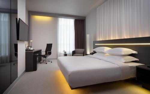 a bedroom with a large white bed and a desk at Four Elements Ekaterinburg in Yekaterinburg