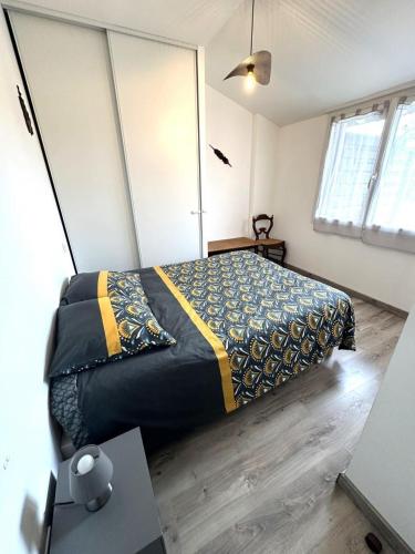 a bedroom with a bed and a table in it at La sauvagine in Soustons